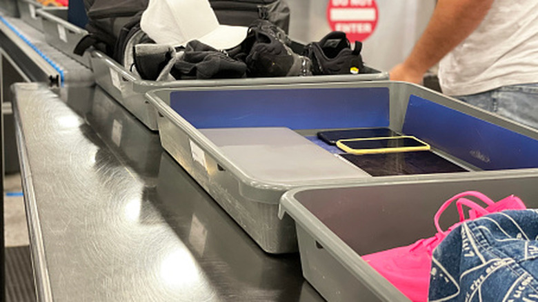 laptop, smartphone, and other electronic devices in a bin to go through the TSA checkpoint