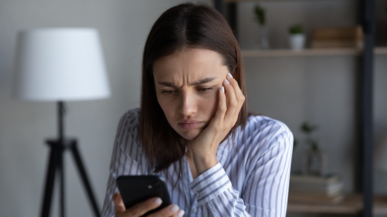 person frowning at their smartphone