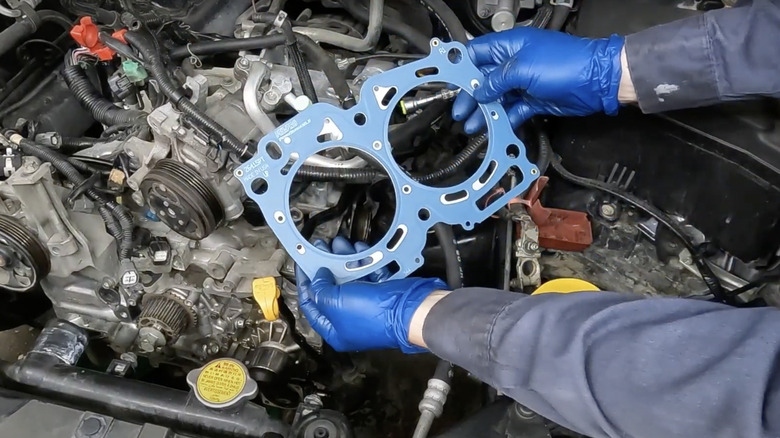 Mechanic with blue gloves replacing Subaru head gasket