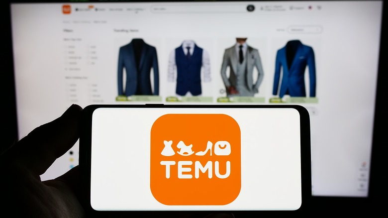 Phone with Temu logo against computer