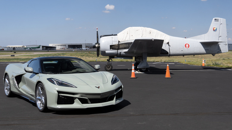 2024 Chevrolet Corvette E-Ray in front of plane