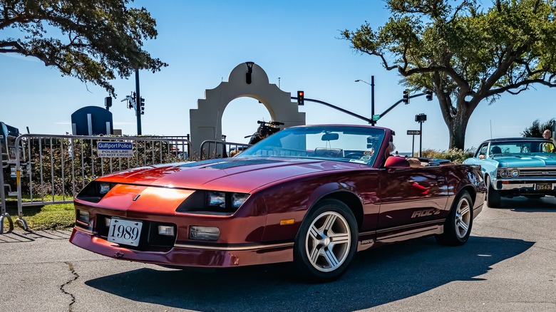 1989 Chevy Camaro convertible parked on road near white cement archway