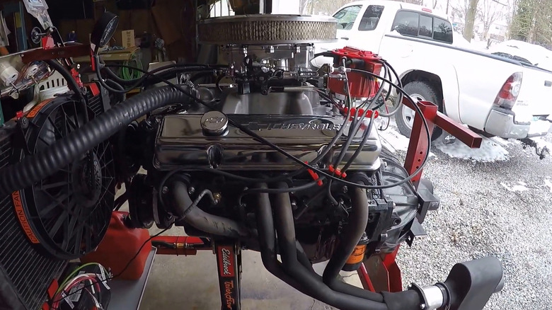 Chevy 305 engine on stand in garage with door open