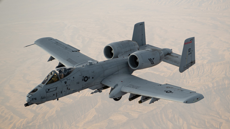 A pilot flying a Warthog over a deserted land