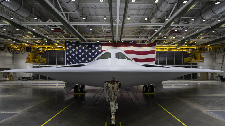 B-21 Raider pictured in a hangar with American flag in the background