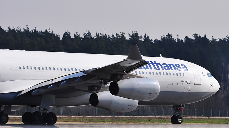Closeup of a white Lufthansa Airlines Airbus A340-300 at an airport on a gloomy day