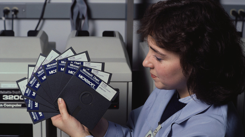 A woman holding floppy discs