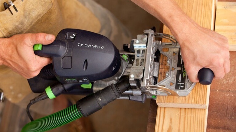 Person using Festool Domino Joiner on wood board