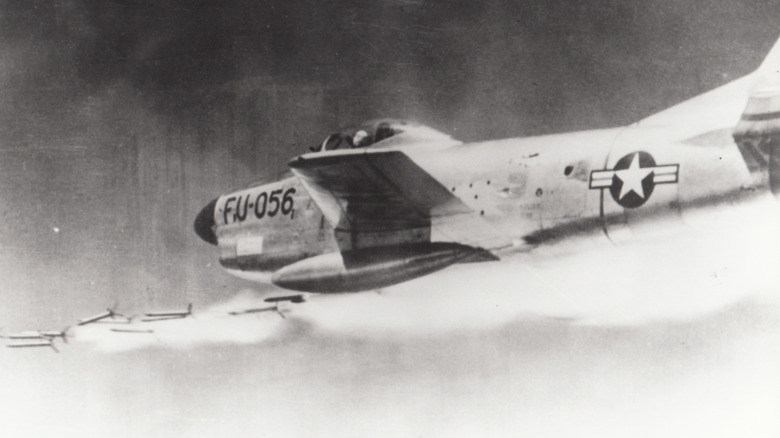 Black and white photo of an F-86D Sabre firing a barrage of Mighty Mouse rockets