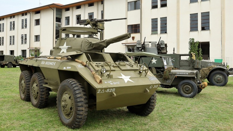 M8 light armored vehicle parked on grass in front of building