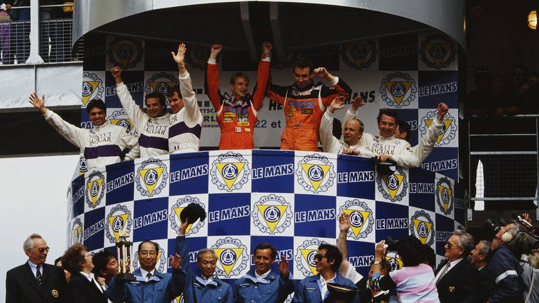 Mazda drivers (in orange) celebrate winning the 1991 24 Hours of Le Mans on the podium next to the Jaguar drivers
