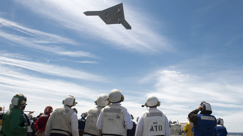 Military personnel watch X-47B fly