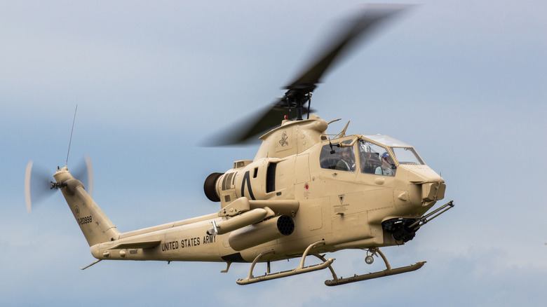 An AH-1 Cobra gunship hovering over the ground