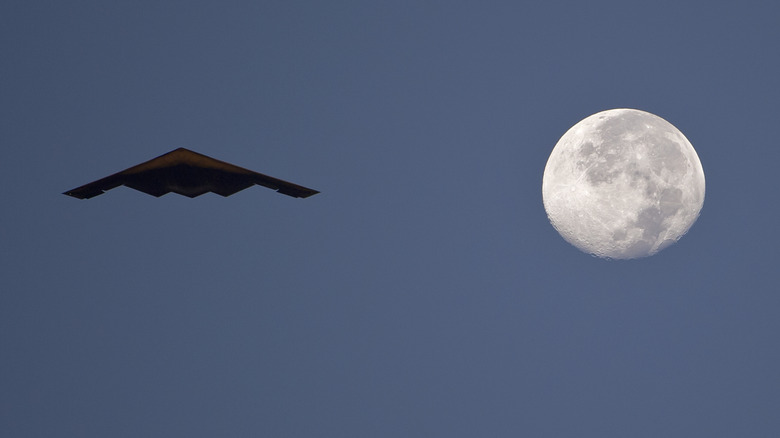 B-2 Spirit flying and moon behind it