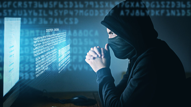 Artist's rendering of a hacker sitting in front of a computer with code projected out from the screen