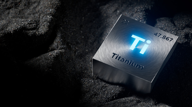 Titanium periodic table element metal block on black powder