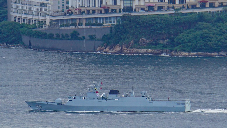A corvette warship sails along waterway.