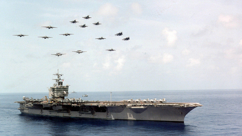 A formation of aircraft flying above the USS Enterprise