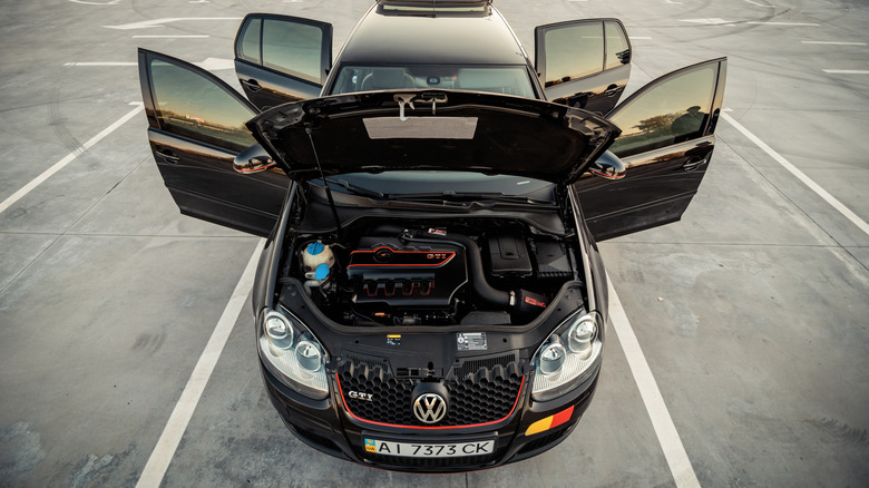 A black Mark V Volkswagen GTI with its hood, doors, and trunk open.
