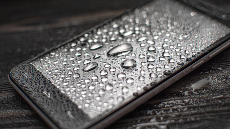 Smartphone with water droplets on oleophobic-coated screen/glass