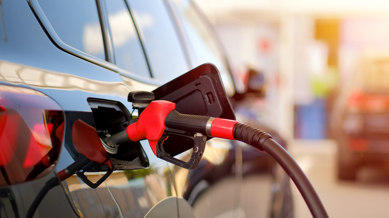 Red gas pump nozzle in an SUV