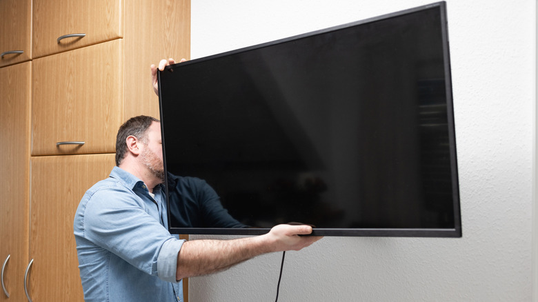 Man installing wall-mounted TV