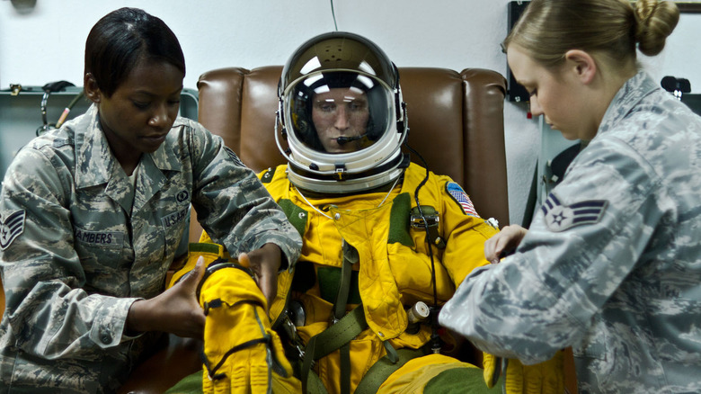 PSD members assisting the pilot in putting on the S-1010 suit