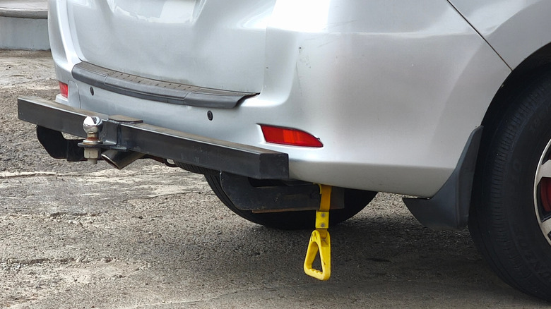 A white SUV showcasing an off-road towbar, a chrome tow ball, and a yellow strap.