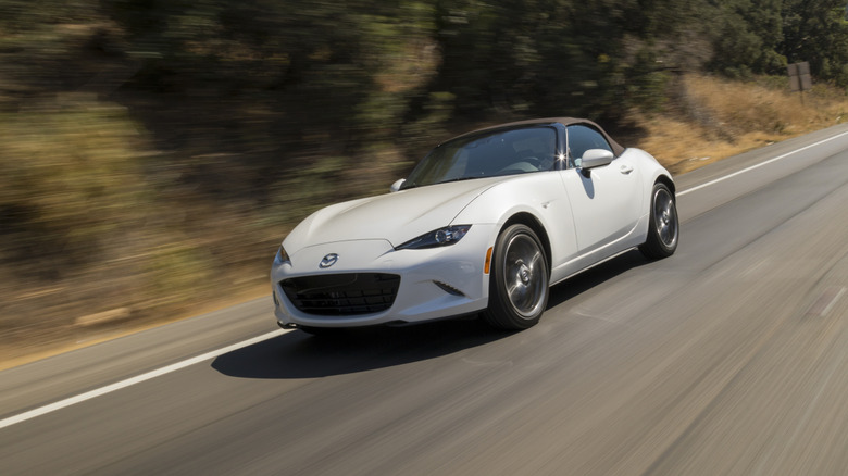 Front 3/4 shot of a 2023 Mazda MX-5 Miata driving down a road