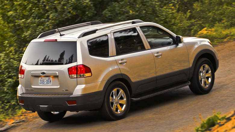 Rear view of a silver 2009 Kia Borrego on a rural road