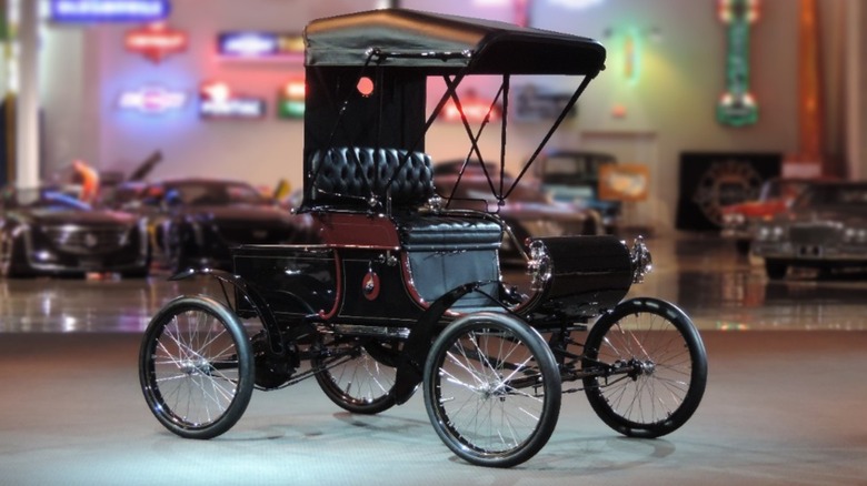 A 1903 Oldsmobile Curved Dash in a museum, front 3/4 view