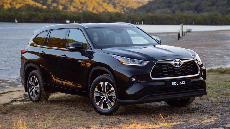 Toyota Kluger by a lake in black, front 3/4 view