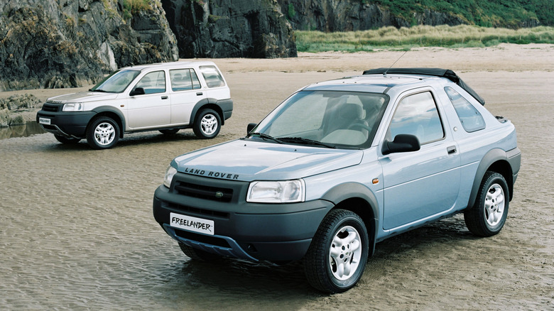 A pair of Land Rover Freelanders on a beach, one convertible and one five-door
