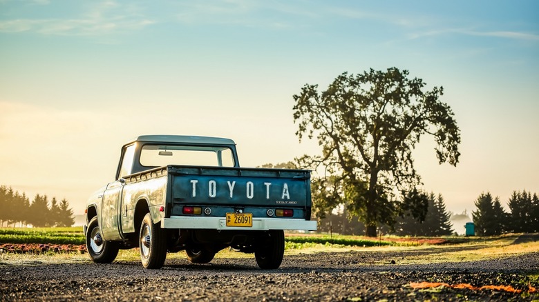 The Stout parked on a gravel path with a tree in the background, rear 3/4 view