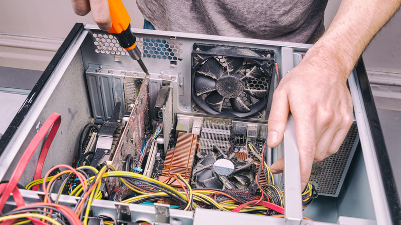 man cleaning dirty PC filled with dust