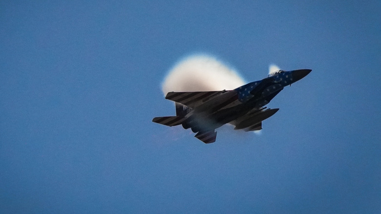 fighter jet in flight with sonic boom clouds