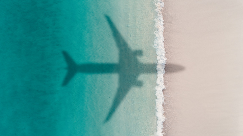 The Shadow Of A Passenger Jet Over A Coastline
