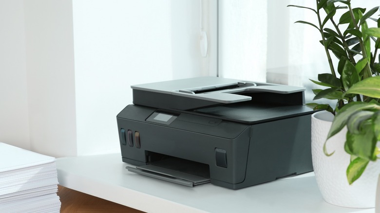 Printer on a desk beside a window
