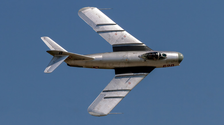 A vintage MiG-17 fighter jet performs a topside pass during a flight demonstration