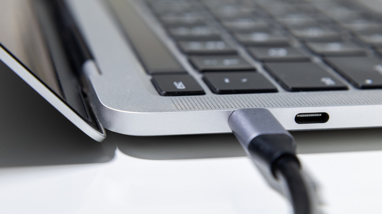 A close up of a USB-C cable plugged into a laptop
