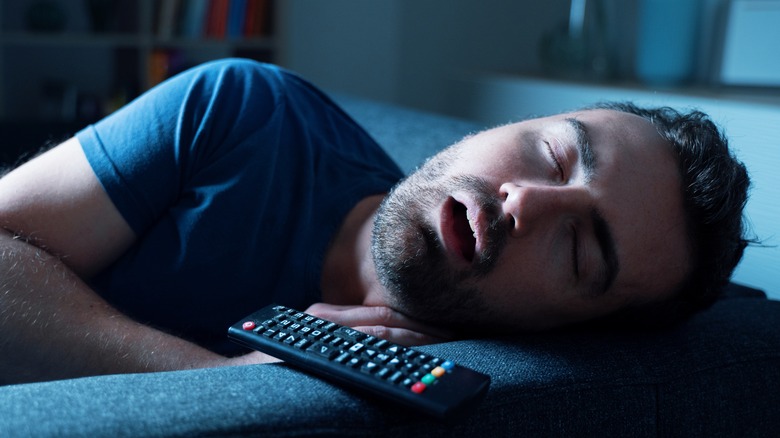 Man sleeping next to TV remote