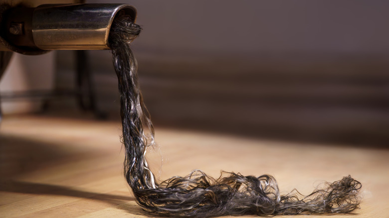 A tuft of long black hair coming out of a car exhaust