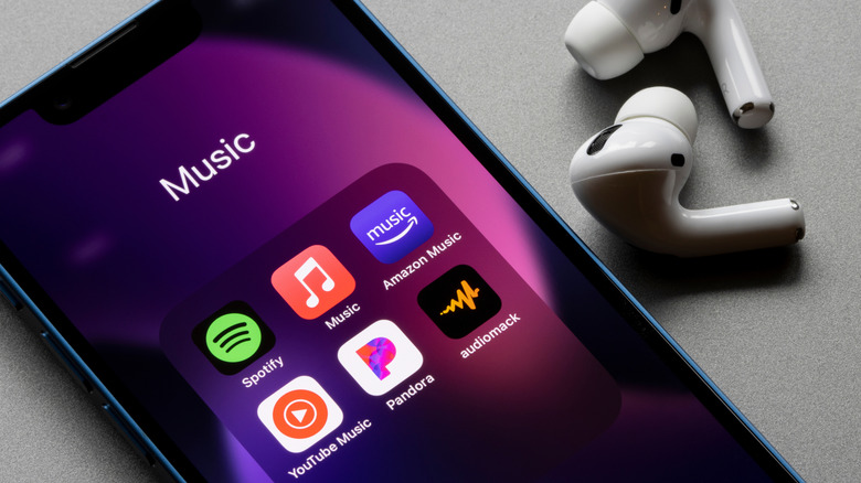 Smartphone with various music apps including Spotify and Amazon Music