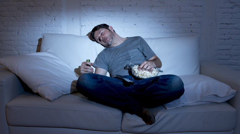 Man sleeping in front of the TV on couch