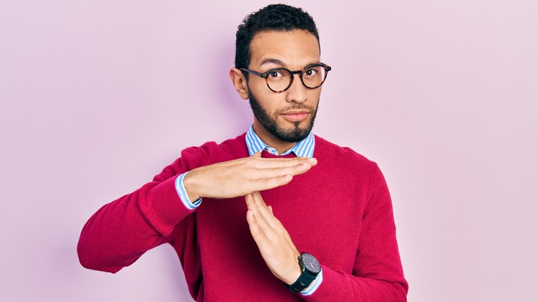 Person making "time out" hand gesture