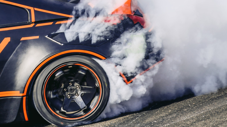 Rear-left wheel of Nissan 350Z drift car skidding on track