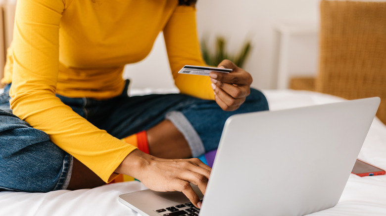 Woman using credit card to purchase something online