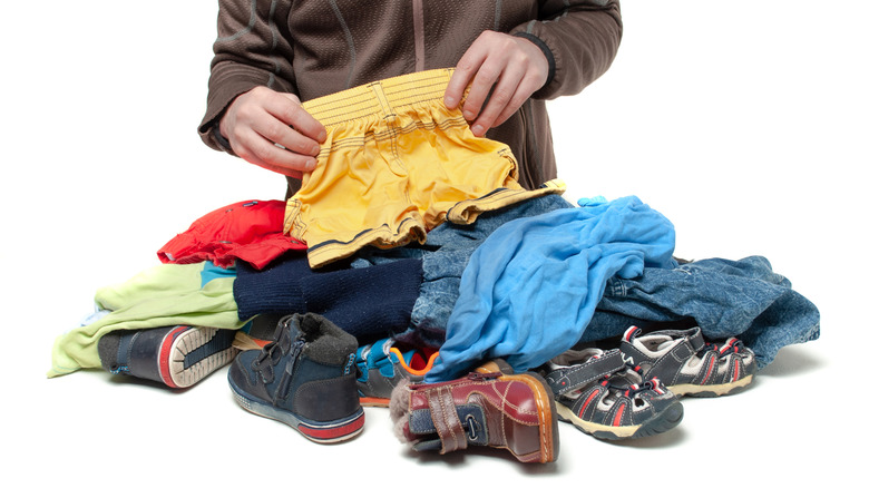 A Person Sorting Second-Hand Children's Clothes