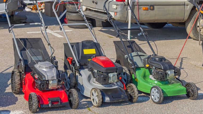 Used lawn mowers for sale at a flea market.