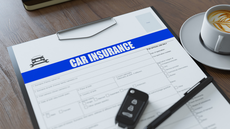 Generic car insurance form on a desk with a car key fob and pen